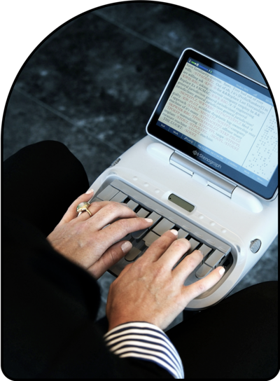 woman's hands typing on stenograph machine